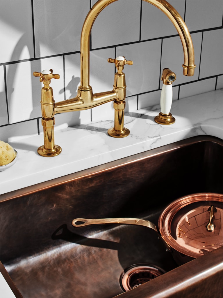 EASTON CLASSIC FAUCET IN UNLACQUERED BRASS, NORMANDY COPPER FARMHOUSE SINK, ARCHITECTONICS BACKSPLASH IN CREAMWARE, AND KEYSTONE SLAB IN CALACATTA